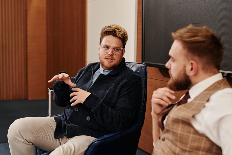 Two business professionals engaged in a focused discussion in a modern office setting.